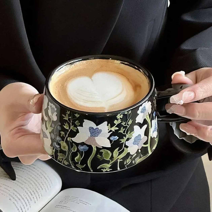 Black ceramic cup with latte on luxury coffee table, elegant desk setup for stylish coffee moments