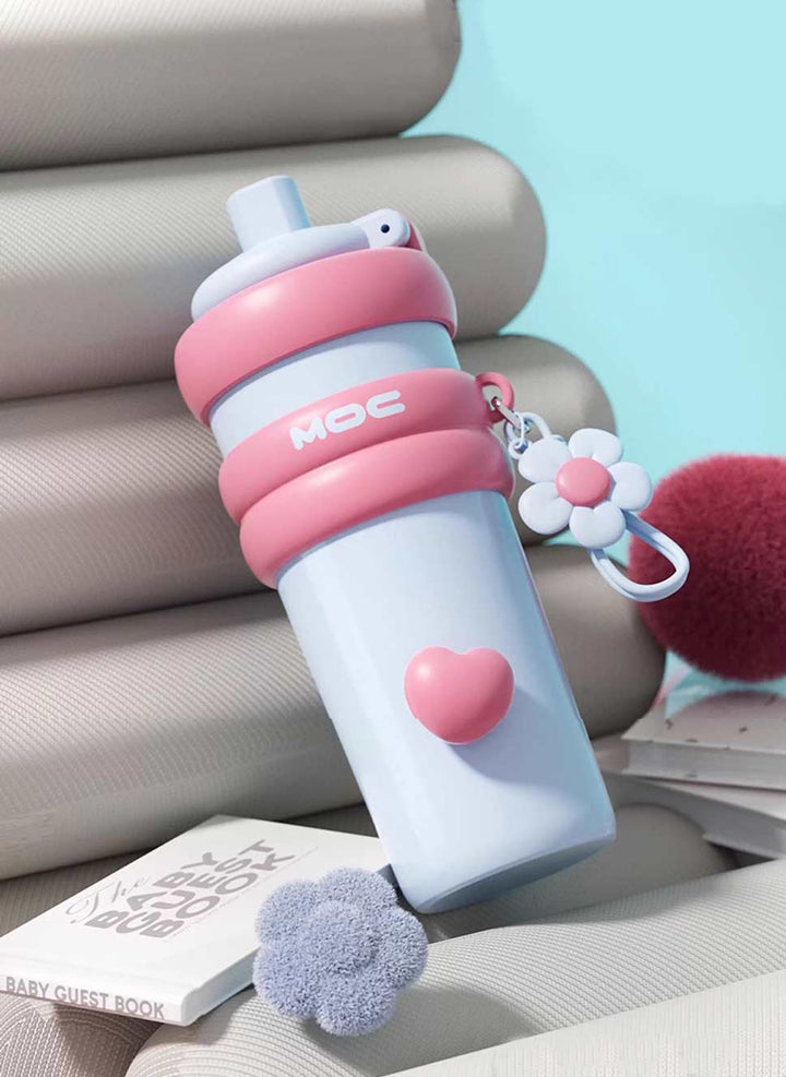 MyLaEvo light blue bottle with pink accents leaning against books, pastel decor