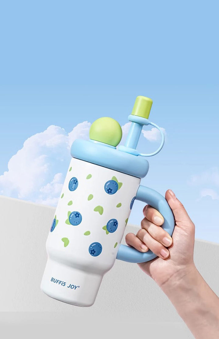Hand holding blueberry print bottle with blue sky background, fresh and playful hydration vibe