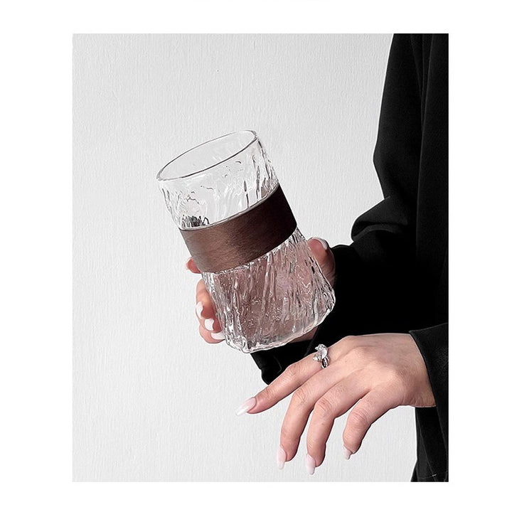 Close-up of glass coffee cup held by woman, stylish setup highlighting elegant coffee moments