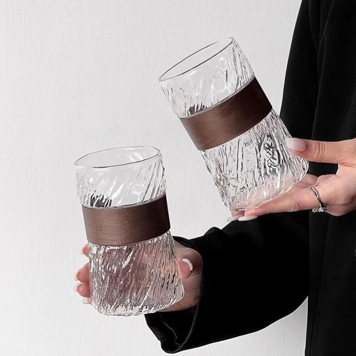 Close-up of woman holding two glass iced coffee cups, stylish setup highlighting elegant and refined design