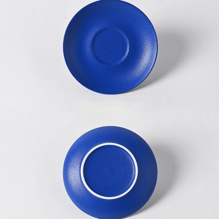 Close-up of Klein blue ceramic cup and saucer front and back, highlighting elegant refined design
