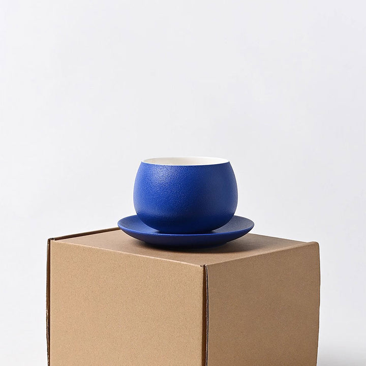Elegant Klein blue ceramic coffee cup on eco-friendly packaging, minimal white background for luxury display