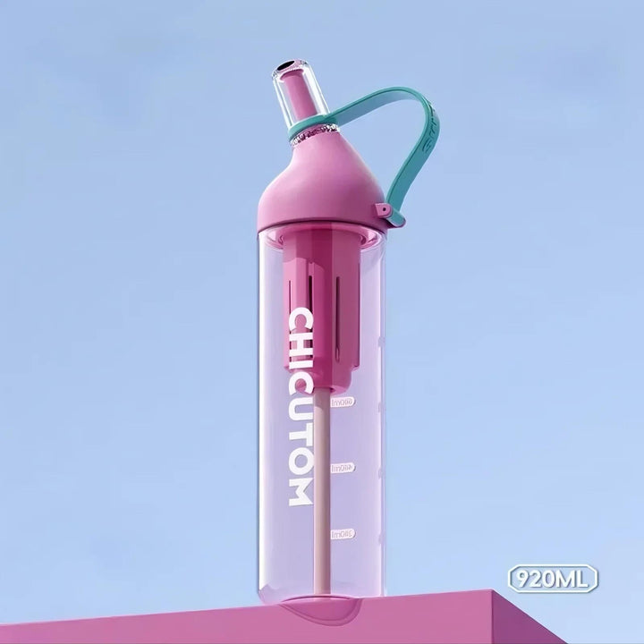 Pink water bottle on pink surface with light green strap against blue background, highlighting soft contrast.