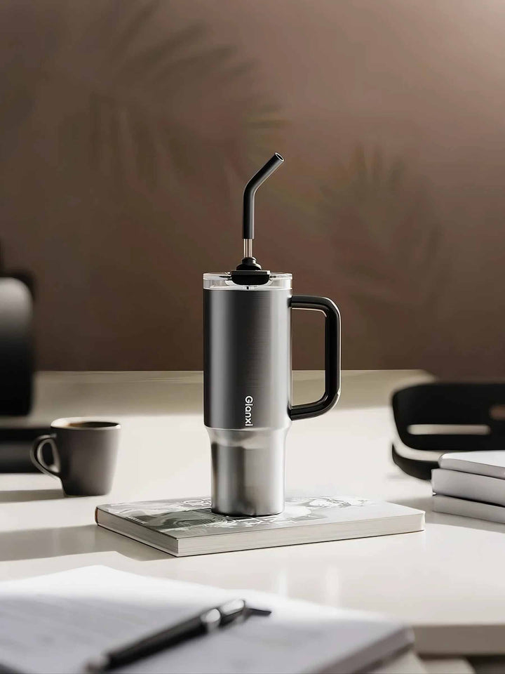 Silver tumbler placed on books with clean desk setup, showing minimal workspace vibe – MyLaEvo.