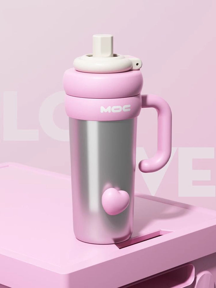 MyLaEvo stainless bottle with pink handle and heart motif on pink plate and backdrop