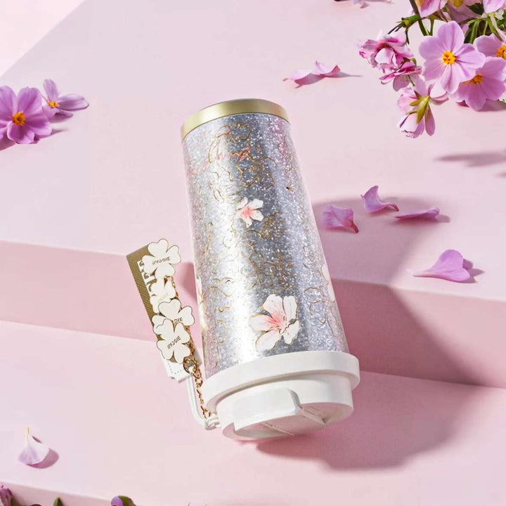 MyLaEvo natural titanium cup with pink floral design, shown upside down in pink setting to highlight leakproof feature