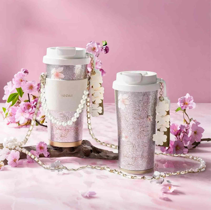 Two MyLaEvo titanium cups, one with pearl strap, in pink floral setting