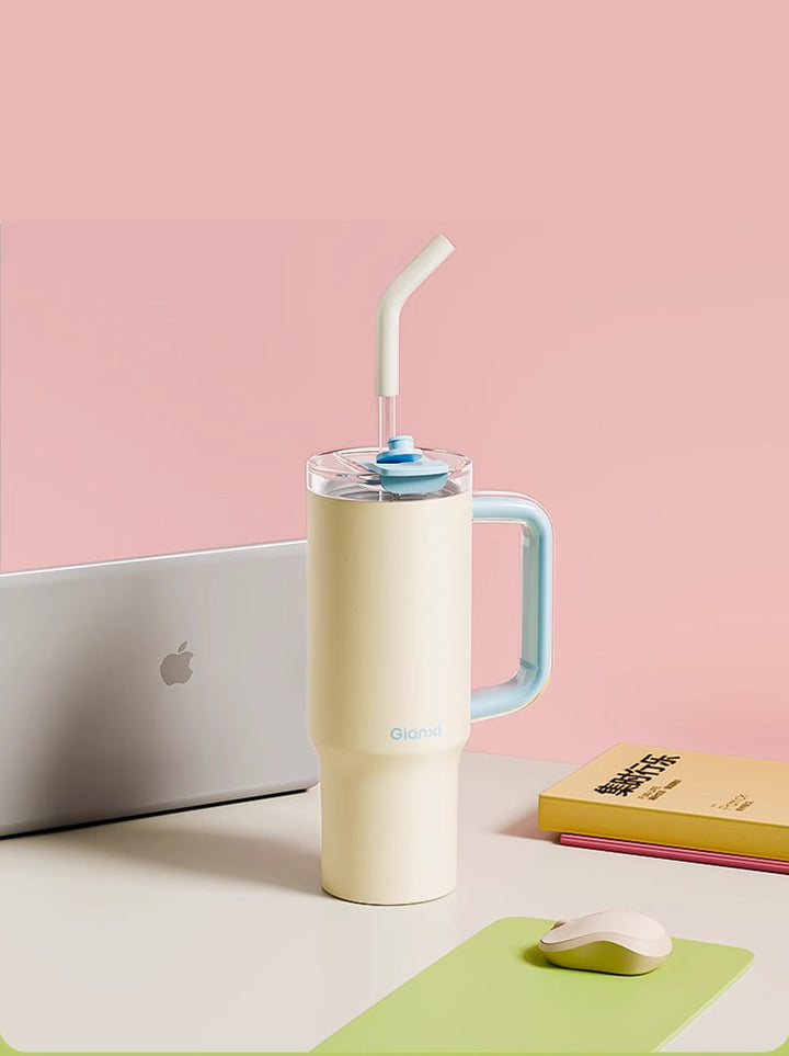 Yellow water bottle on white desk with laptop and books against a soft pink background – MyLaEvo