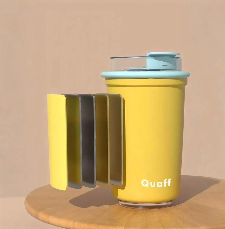 Yellow cup with blue lid on tan background, showing multi-material design of cup body and product texture details.