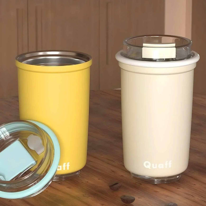 Yellow and white cups on minimalist background; yellow cup lid open, showing simple and elegant design.